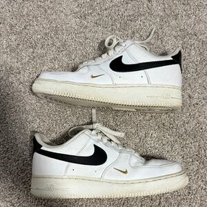 Nike Air Force 1 White Sneakers with Black and Gold Accents